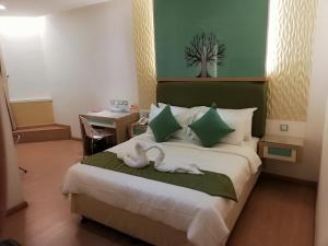 Una habitación de hotel con una cama con dos cisnes. en Holiday Place Kuala Lumpur en Kuala Lumpur