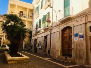 a street with buildings and a palm tree next to a building at Al Giordano in Foggia
