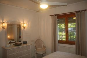 a bedroom with a bed and a dresser and a window at Las Bellotas in Moraira