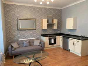 a living room with a couch and a table at The Snug Garden Apartment in Llandudno