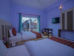una camera d'albergo con due letti e una finestra di Hotel City Palace a Pokhara