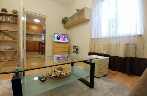 a living room with a glass table and a television at Apartament Oficyna in Krakow