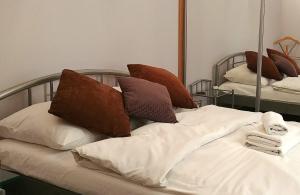 a bed with pillows on it in front of a mirror at Apartament Oficyna in Krakow