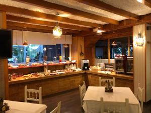 a kitchen with two tables and a counter with food at Hotel La Duquesa in Pinos Genil