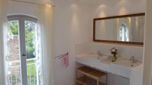 a white bathroom with two sinks and a mirror at Landhaus Sinneswandel in Nauen