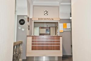 a hotel lobby with a reception desk and a sign at DS Akademia Muzyczna in Kraków