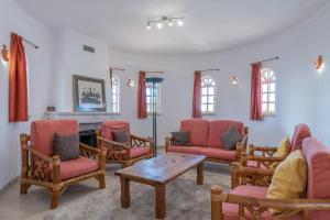 ein Wohnzimmer mit roten Stühlen und einem Kamin in der Unterkunft Villa Nora by Gabi Miguel in Albufeira