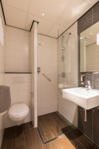 a bathroom with a toilet and a sink and a shower at Hotel Amsterdam De Roode Leeuw in Amsterdam