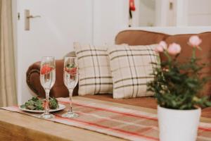 a table with two wine glasses and a plate of food at The King Street Holiday Apartment in Inverness City Centre in Inverness