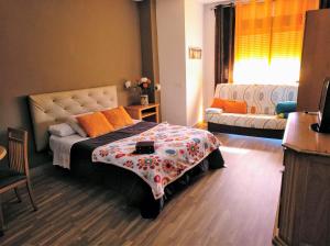 een slaapkamer met een bed en een bank erin bij Apartamento Domingo Lozano in Málaga