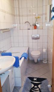 a white bathroom with a sink and a toilet at Ferienwohnung Gladbeck-Rohde in Gladbeck