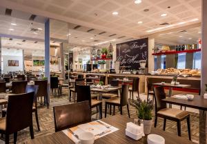 un restaurante con mesas y sillas de madera y una barra en Astral Maris Hotel en Eilat