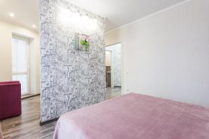 a bedroom with a pink bed and a wall at Apartment on Oktyabrskaya in Kaliningrad