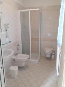 a bathroom with a shower and a toilet and a sink at Residence Onda Blu in Cervia