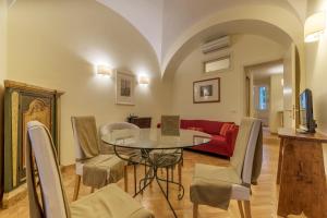 a living room with a table and a red couch at Casa Cornacchie - FromHometoRome in Rome