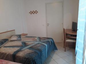 1 dormitorio con cama, escritorio y silla en Residence Onda Blu en Cervia