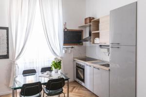 Il comprend une petite cuisine équipée d'une table et d'un réfrigérateur. dans l'établissement Menabrea 33 - stylish apartment!, à Milan