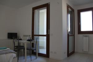 uma sala de jantar com uma mesa e uma porta de vidro em Luxory Suites em Sesto San Giovanni
