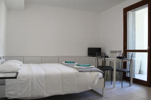 um quarto com uma cama, uma mesa e uma secretária em Luxory Suites em Sesto San Giovanni