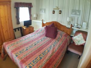 a bedroom with a bed and a desk at White House Country Inn in Sennybridge