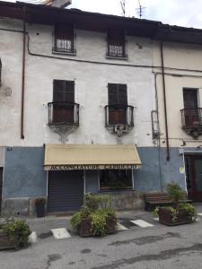 ein Gebäude mit einem Laden mit Markise und Pflanzen davor in der Unterkunft la petite maison in Aosta