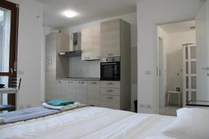 um quarto com uma cama branca e uma cozinha em Luxory Suites em Sesto San Giovanni