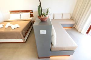 - une chambre avec un lit et une plante sur une table dans l'établissement Portofino Pousada, à São Miguel do Gostoso