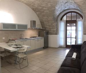 Una cocina y una sala de estar con un sofá y una mesa. en Appartamenti Gardastivo, en Arco