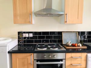 a kitchen with a stove and a counter top at The Winter Garden Suites in Blackpool