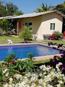 a house with a swimming pool and flowers at Longan Tree in Ban Nam Thong