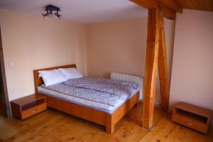 Un dormitorio con una cama en una habitación con suelo de madera. en Dioniss Apartment, en Sibiu