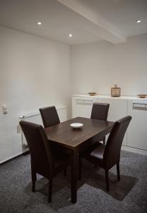 a table and chairs in a room with a kitchen at Boardinghouse Apart-Hotel in Oberkochen