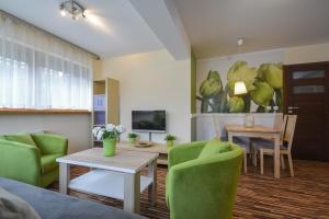 a living room with a couch and a table and chairs at Apartament Krupówki 4 os CENTRUM in Zakopane