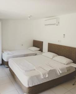 Dos camas en una habitación con paredes blancas. en My Bungalov, en Mesudiye