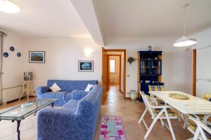 een woonkamer met een blauwe bank en een tafel bij Fontana Vecchia Seaview Apartment in Taormina