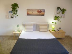 een slaapkamer met een groot bed en 2 tafels bij EcoBoutique house, self check-in - free car parking in Cagliari