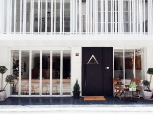 a white building with a black door at Varmtel in Bangkok