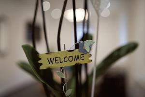 een teken dat zegt welkom hangend aan een plant bij Boardinghouse Apart-Hotel in Oberkochen