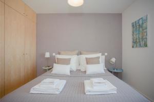 - une chambre avec un lit et des serviettes blanches dans l'établissement Liiiving in Porto | Bright Light Apartment, à Porto