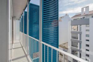 - un balcon avec volets bleus dans un bâtiment dans l'établissement Liiiving in Porto | Bright Light Apartment, à Porto
