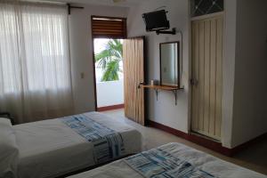 a bedroom with two beds and a mirror and a window at Hotel Carruiz in Puerto Escondido +44 photos