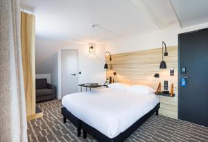 a bedroom with a large white bed and a couch at ibis Styles Laval Centre Gare in Laval