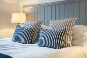 a bed with two blue and white pillows on it at Una St Ives in St Ives