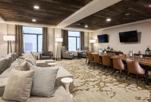 a living room with a couch and a table and chairs at Pomeroy Inn & Suites Prince George in Prince George