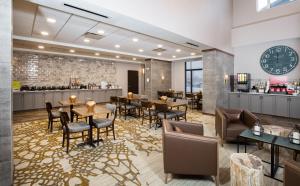 um restaurante com mesas e cadeiras e um bar em Pomeroy Inn & Suites Prince George em Prince George