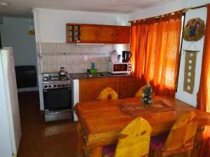 a small kitchen with a wooden table and a stove at Laguna Verde Departamentos in Villa Pehuenia