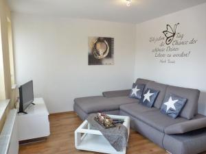 Una sala de estar con un sofá y un televisor. en Ferienwohnung zum Yachthafen, en Waren
