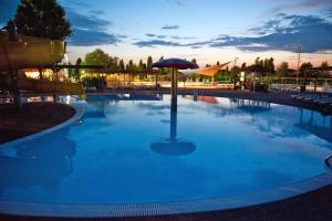 una gran piscina con una sombrilla en el medio en Barricata Holiday Village, en Scardovari