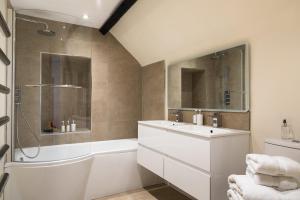 y baño con bañera, lavamanos y ducha. en Luxury 3 Bed flat in the centre of Woodstock, en Woodstock