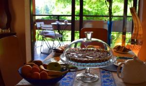 stół z ciastem w szklanym talerzu w obiekcie B&B La Dimora di Charme w mieście Basiglio
